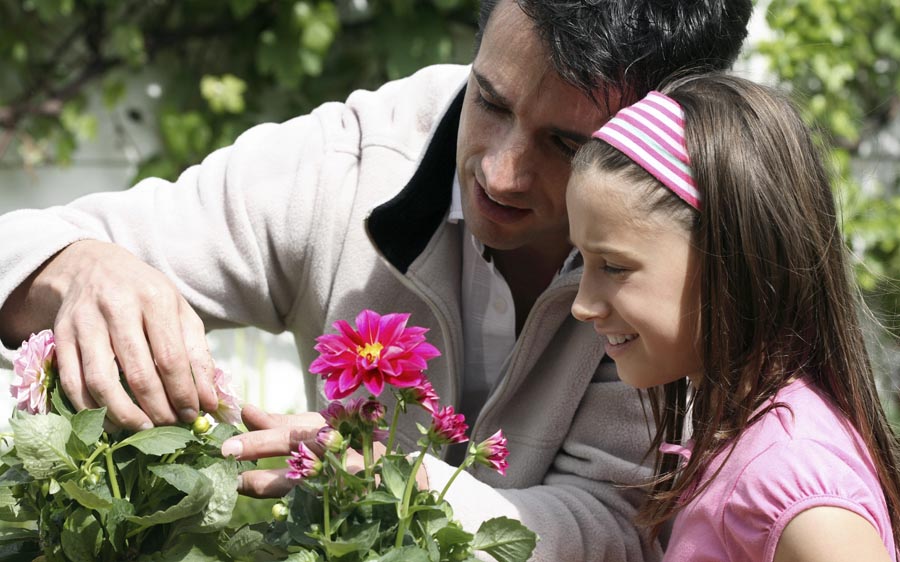 Father and daughter looking at plants