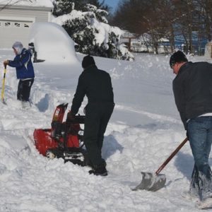 People shovelling snowy yard