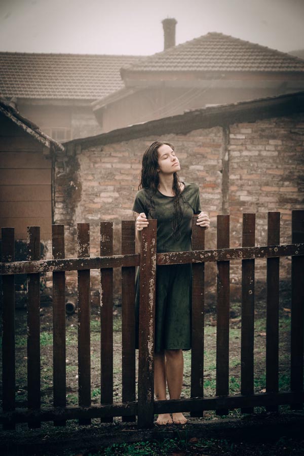 Lady in front of fence