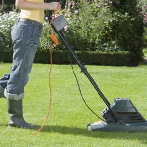 Woman Mowing Lawn With electric Lawn Mower