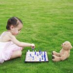 Girl playing draughts with teddy