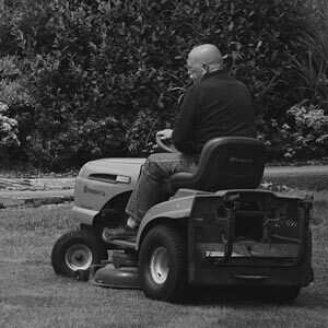 Man on riding mower cutting grass