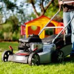 Front of lawn mower on lawn with man behind