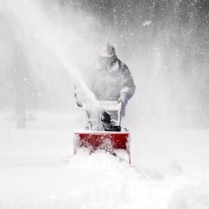 Person using snow blower to clear snow